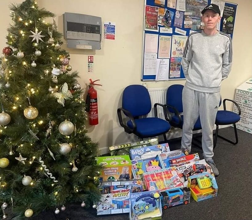 Aiden from Clearer Window Solutions donating Christmas presents at Ferry Bridge Community Centre